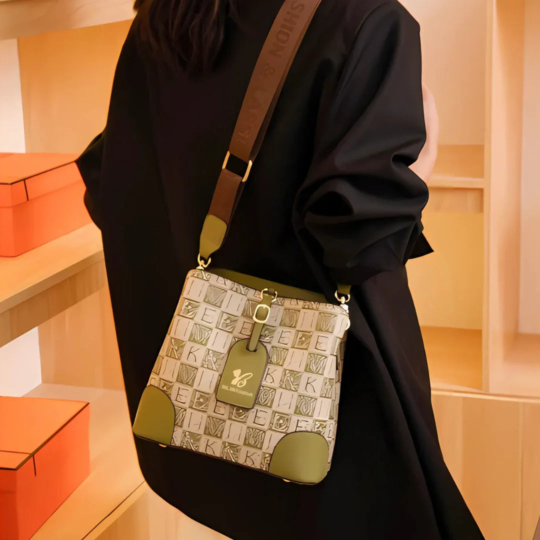 Woman in black outfit with stylish monogram crossbody bag in modern boutique setting