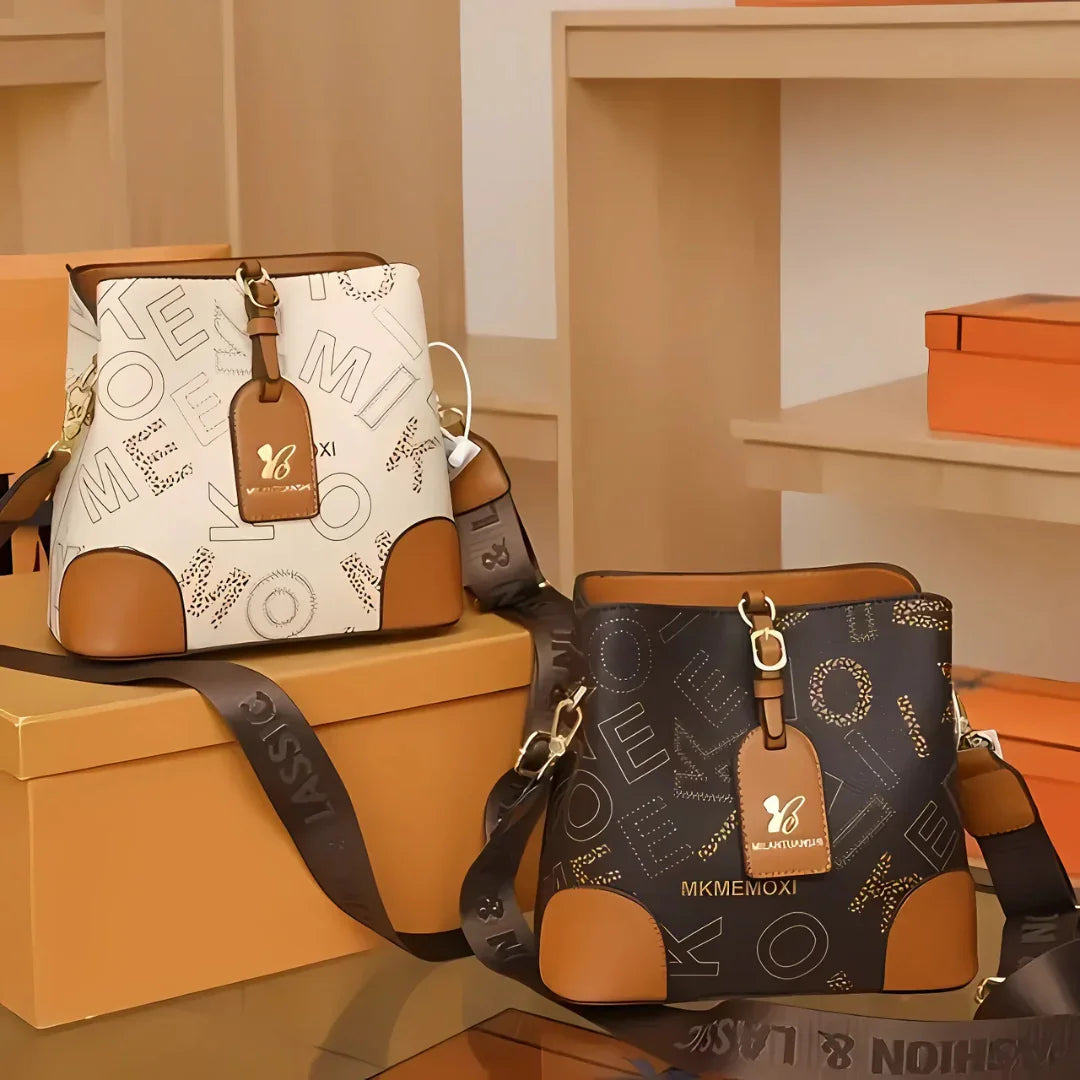 Two designer shoulder bags with MKMEMOXI branding, brown accents, displayed on boxes