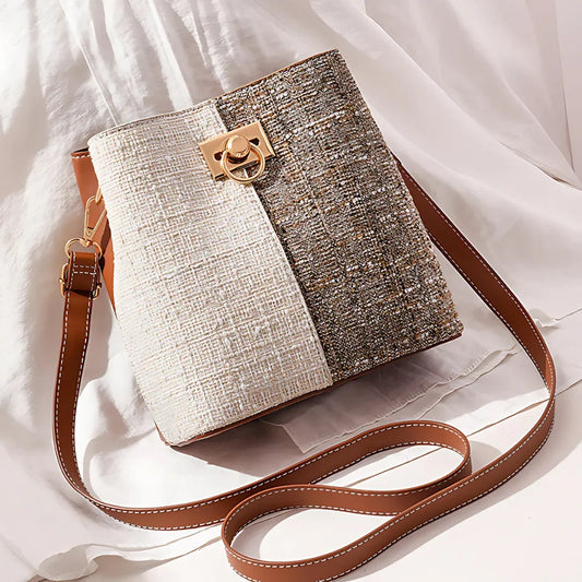 Two-tone tweed crossbody shoulder bag with gold clasp and brown strap on white fabric