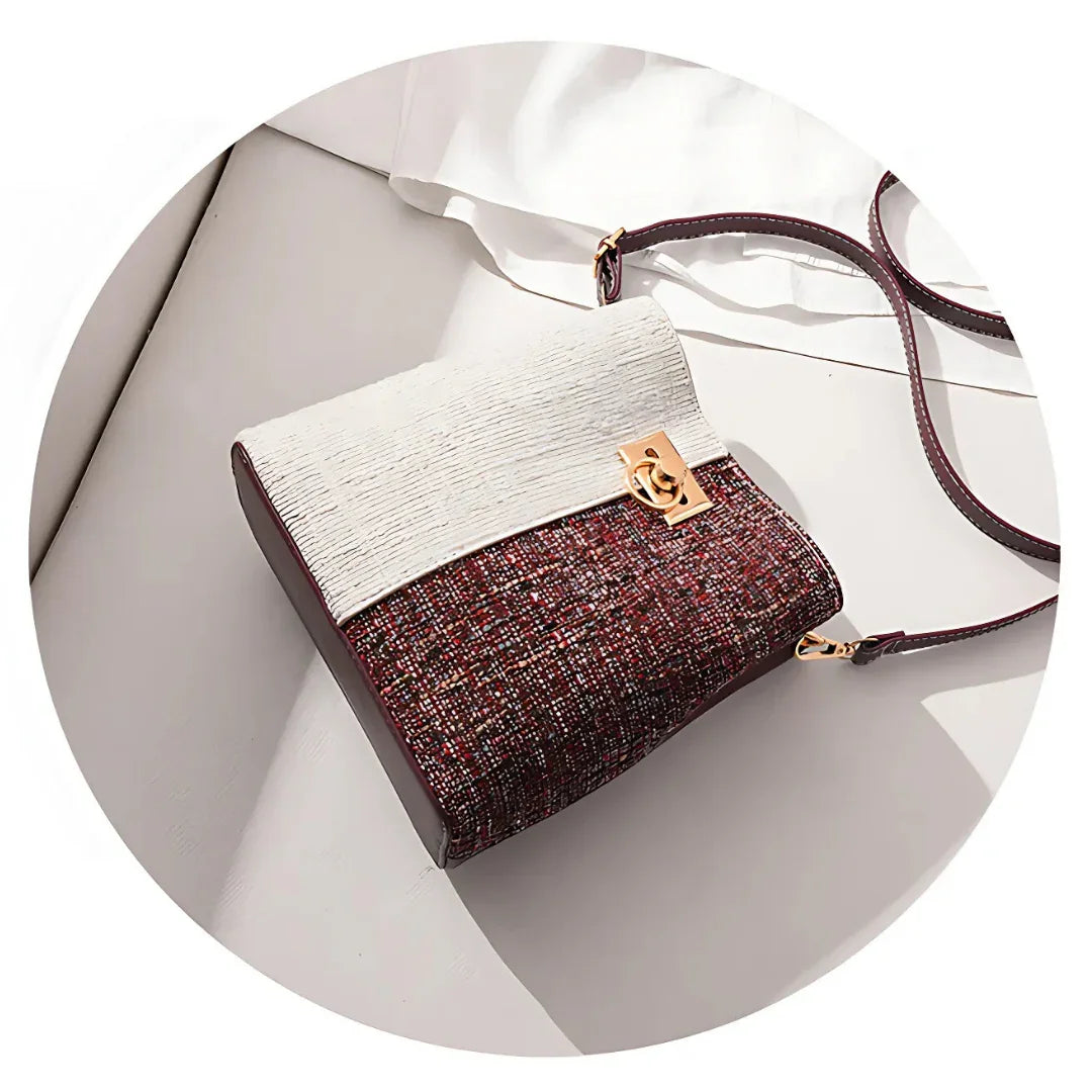 Chic crossbody bag with textured white flap, burgundy tweed body, and gold clasp on white surface