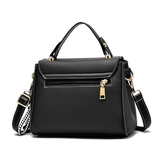 Black leather handbag with gold zipper, handle, adjustable strap, and white stitching