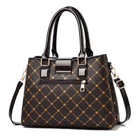 Black leather handbag with gold geometric pattern, top handles, and detachable strap