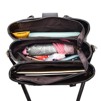 Top view of organized black tote bag filled with laptop, umbrella and daily essentials