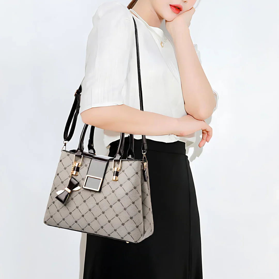 Woman in white blouse holding designer tote bag with geometric pattern and black strap