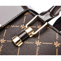 Close-up of brown designer handbag with gold hardware and floral pattern