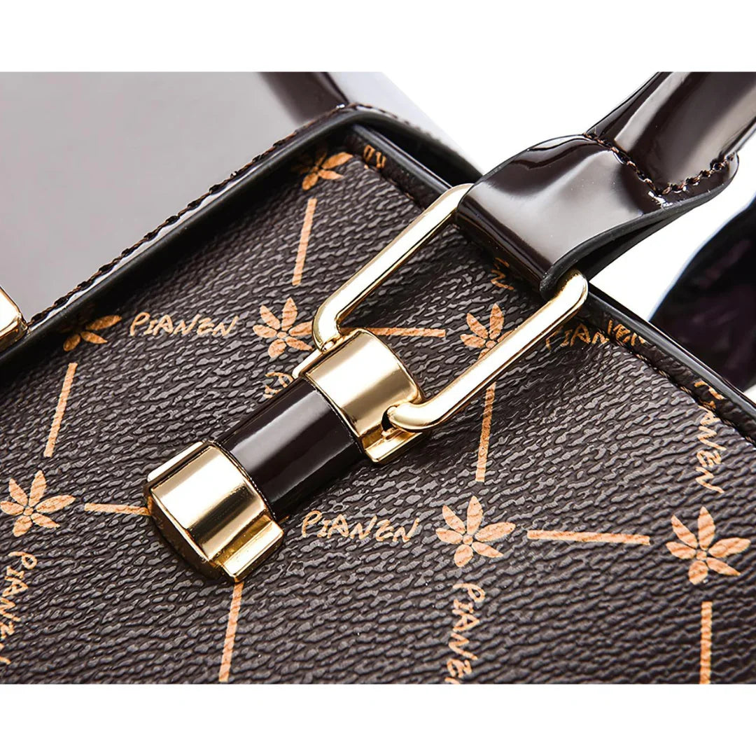 Close-up of brown designer handbag with gold hardware and floral pattern