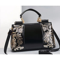 Black patent leather handbag with gold floral embroidery and gold hardware