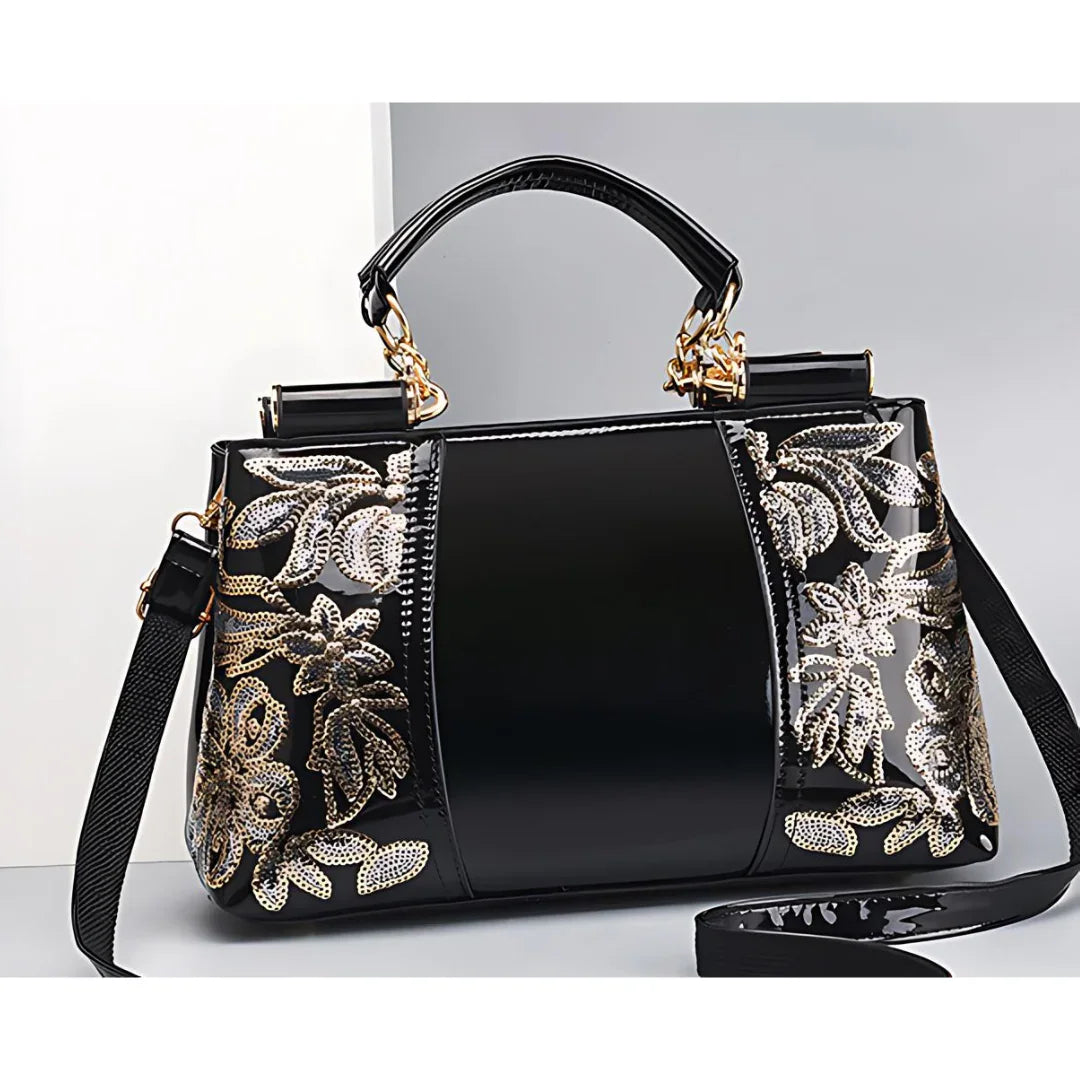 Black patent leather handbag with gold floral embroidery and gold hardware