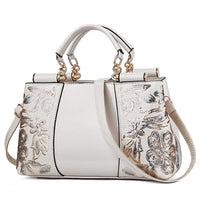 White handbag with gold hardware and silver floral sequin embroidery, elegant purse