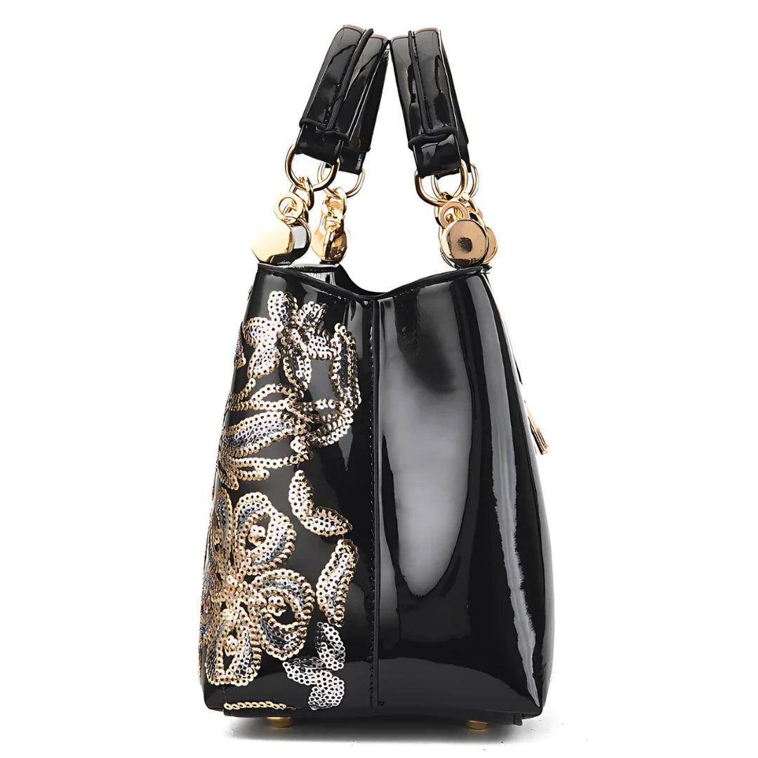 Glossy black handbag with gold floral sequins and gold hardware side view