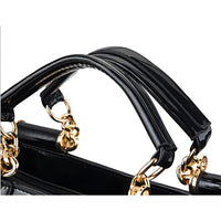 Black patent leather handbag with gold chain handles close-up