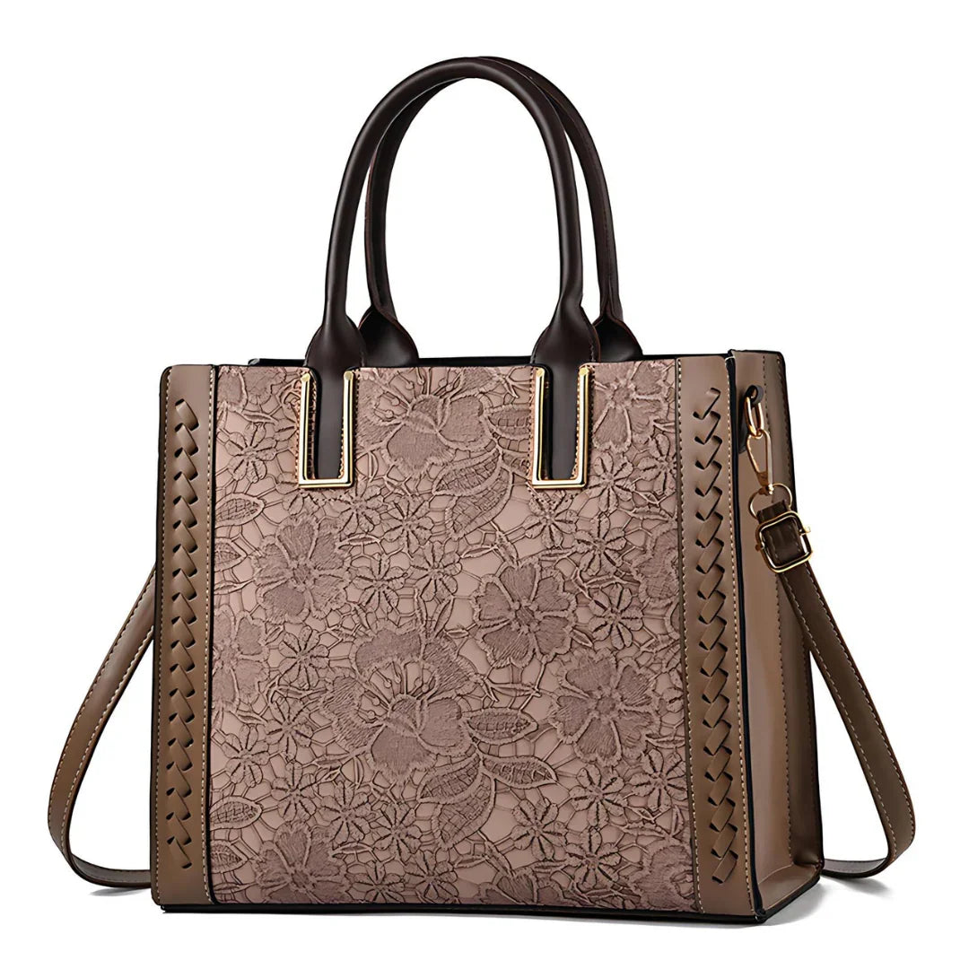 Brown floral handbag with lace pattern, leather accents, and gold hardware
