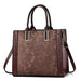 Brown leather tote bag with floral lace pattern and double handles