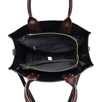 Open black tote bag with brown leather handles and gold zipper pockets
