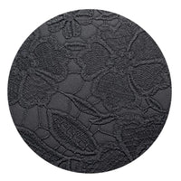 Close-up of black faux leather with embossed floral pattern texture