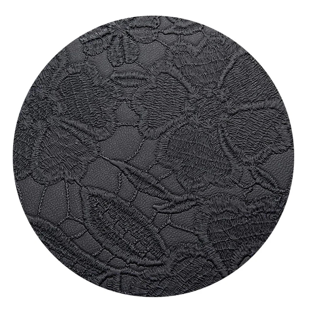 Close-up of black faux leather with embossed floral pattern texture