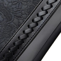 Black leather with embossed floral pattern and woven stitched detail, close-up