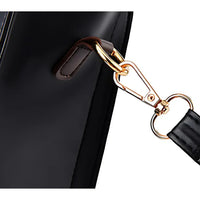 Close-up of black leather bag with gold detachable strap clip