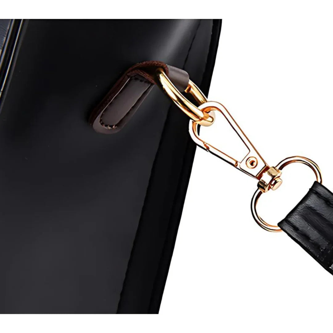 Close-up of black leather bag with gold detachable strap clip