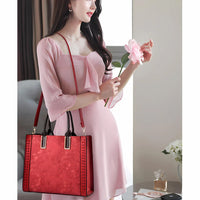 Woman in pink dress holding pink flower and red floral handbag indoors