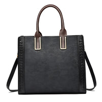 Black floral embossed tote handbag with brown handles and side braid detail