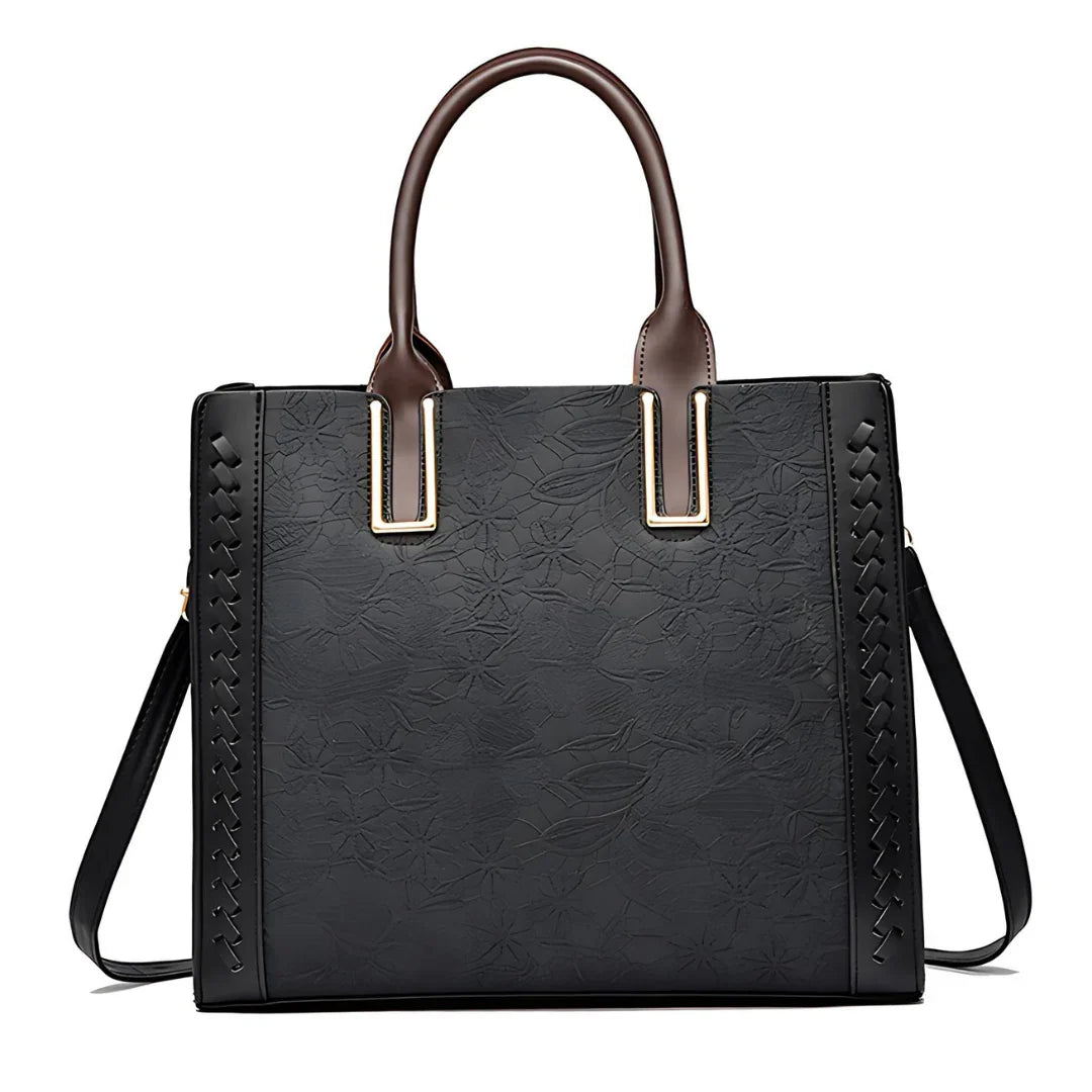 Black floral embossed tote handbag with brown handles and side braid detail