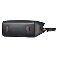 Black leather tote bag bottom view with brown oval feet and gold buckle strap