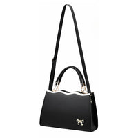 Black handbag with gold bow accent, wavy top edge, and adjustable shoulder strap