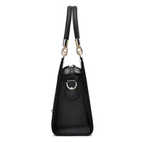 Side view of black leather handbag with gold hardware and double handles