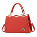 Elegant red women's handbag with gold accents and bow charm, top handle, and shoulder strap