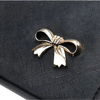 Black textured clutch with gold bow accent