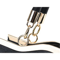 Black handbag close-up with gold metal rings and textured strap detail