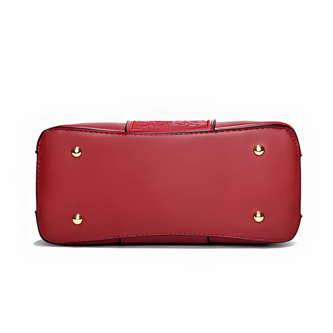 Red leather handbag bottom with gold metal feet on white background