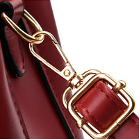 Close-up of red leather handbag with gold buckle and clasp detail