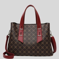 Brown handbag with geometric pattern, red leather handles and strap, on gray background