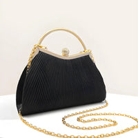 Elegant black pleated handbag with gold handle and chain on a white background