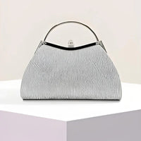 Textured silver handbag with metal handle on geometric white and pastel display