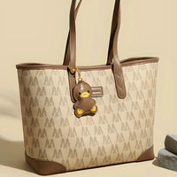 Beige and brown tote bag with duck keychain, monogram pattern, stylish women's handbag