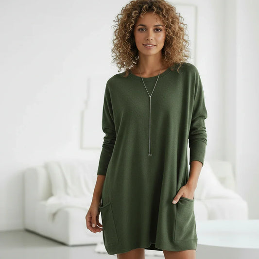 Woman wearing a green long loose sweater in a minimalistic room