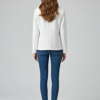 Person wearing a white blazer and blue jeans on a gray background