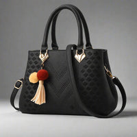 Women's luxury black crossbody handbag with gold accents and tassel charm