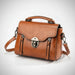 Brown leather crossbody handbag with metal clasp and detachable strap on white background