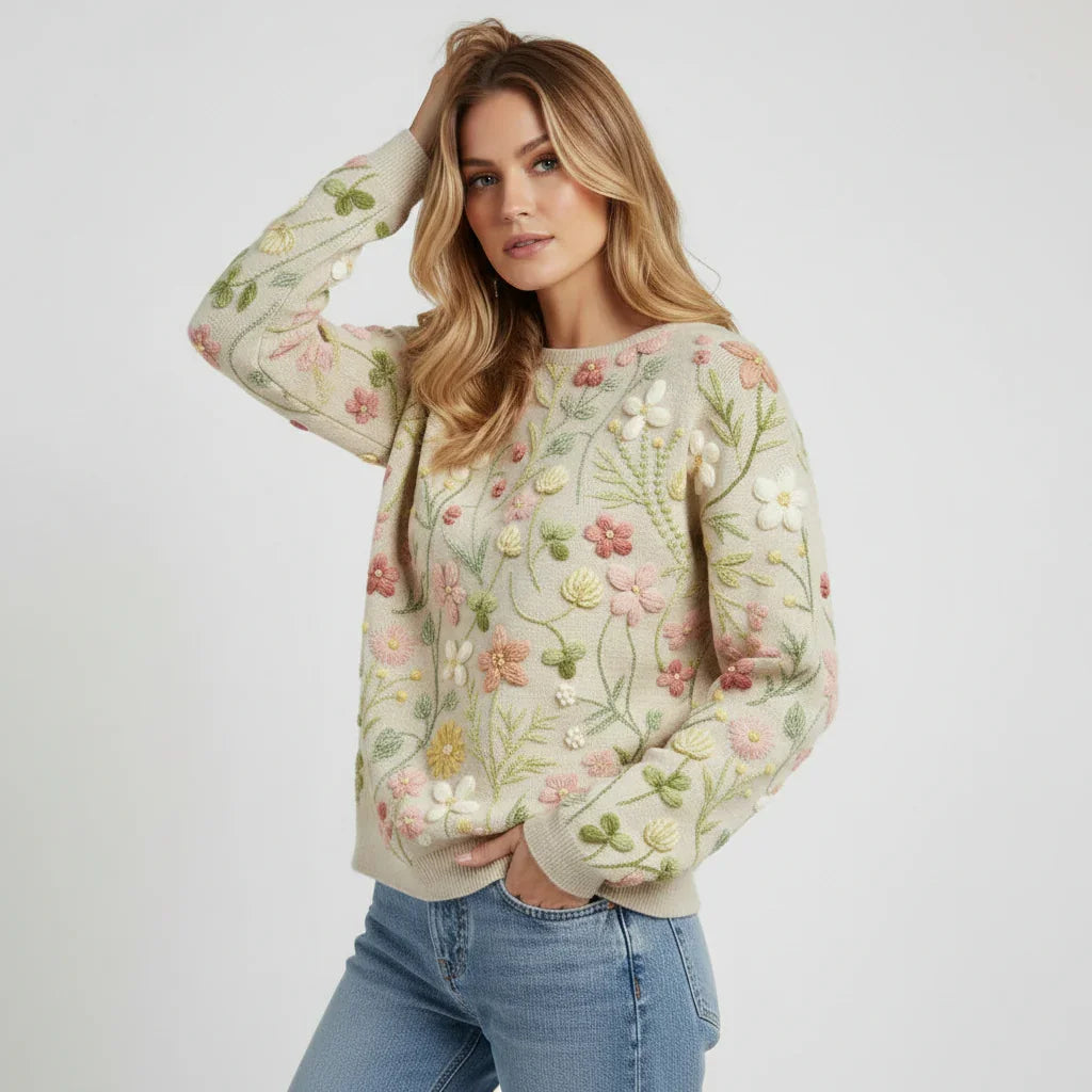 Woman wearing a floral embroidered sweater and jeans on a plain background