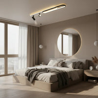 Modern bedroom with large windows, round mirror, and neutral color scheme.