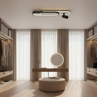 Ceiling light fixture in a room with clothing on a rack and a window.