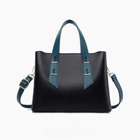 Black leather handbag with blue handles and shoulder strap on white background