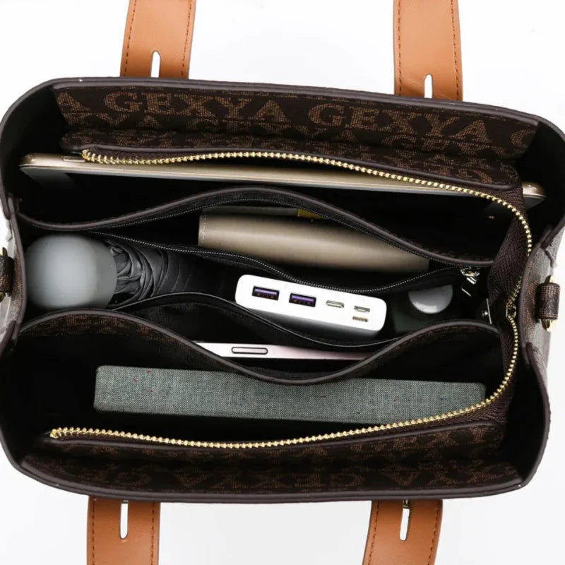 Open brown designer tote bag with organized compartments, holding laptop, umbrella, charger, notebook