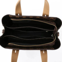 Top view of brown leather handbag with zipper pockets and tan handles