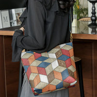 Woman carrying geometric patchwork shoulder bag in modern indoor setting