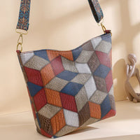 Geometric cube pattern leather shoulder bag with colorful strap on beige background